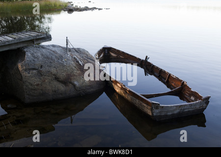 Half sunken wooden rowing boat at a jetty, island of Norrbyskaer, Vaesterbotten, Sweden, Europe Stock Photo