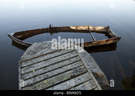 Half sunken wooden rowing boat at a jetty, island of Norrbyskaer, Vaesterbotten, Sweden, Europe Stock Photo