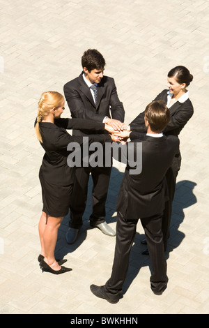 Photo of people standing and stacking their hands Stock Photo
