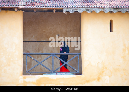 Muslim woman on a mobile phone in Lamu Fort or Fumo Madi ibn Abi Bakr, Lamu Island, Kenya Stock Photo