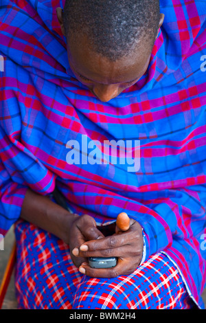 Maasai tribesman using a mobile phone in the Masai Mara, Kenya Stock Photo