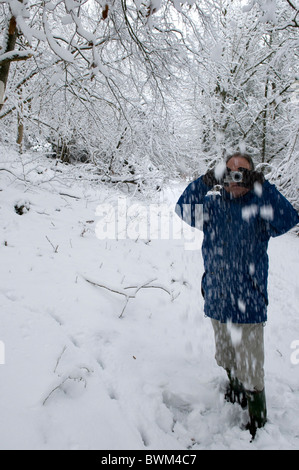 Man using a digital camera to take a photograph in the snow Stock Photo