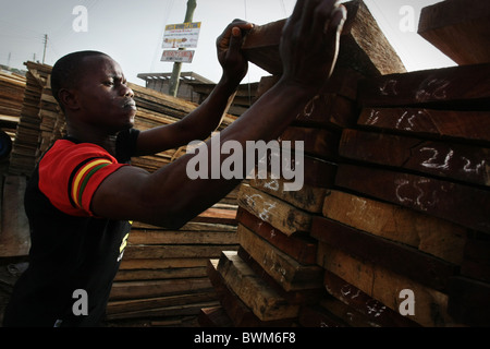 A man sorts wooden boards for sale at the timber market in Tema, Ghana on Tuesday May 20, 2008. Stock Photo