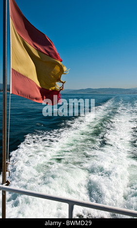 Ship Wake and Spanish Ripped Flag moved by the Wind. Stock Photo