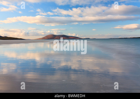 Looking south to Ceapabhal with the white clouds reflecting off the wet sand at Luskentyre Stock Photo