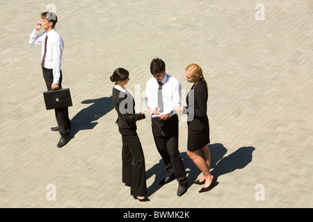 Image of confident business people discussing something outdoor Stock Photo