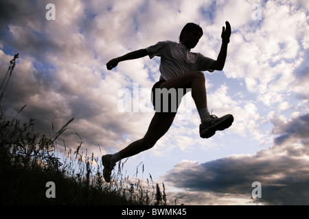 Photo of silhouette of jumping sportsman on a sky background Stock Photo