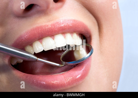 Close-up of female with open mouth during oral checkup at the dentist’s