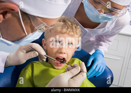 Image of dental examining being given to little boy by dentist and his assistant Stock Photo