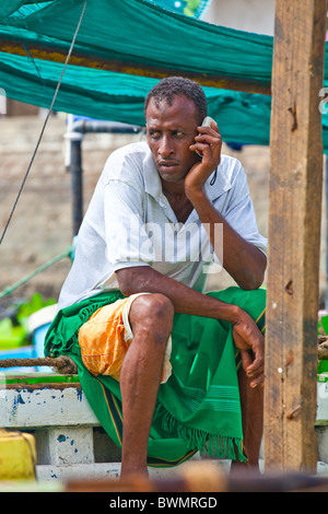 Man on a dhow talking on a mobile phone, Lamu Island, Kenya Stock Photo