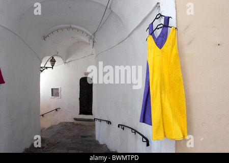 clothes dresses hanging on the wall in Positano alley and arc, Amalfi coast Italy Touristic goods souvenirs Mediterranean destin Stock Photo