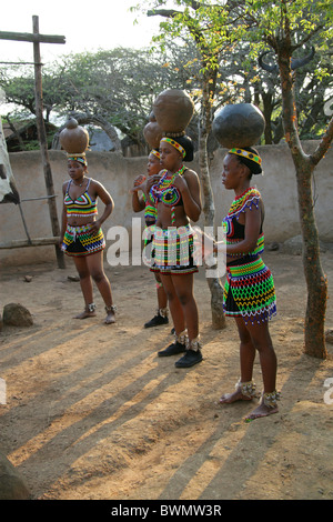 Zulu Girls Wearing Traditional Beaded Dress and Carrying Pots on their Heads, Shakaland Zulu Village, Kwazulu Natal, Africa Stock Photo