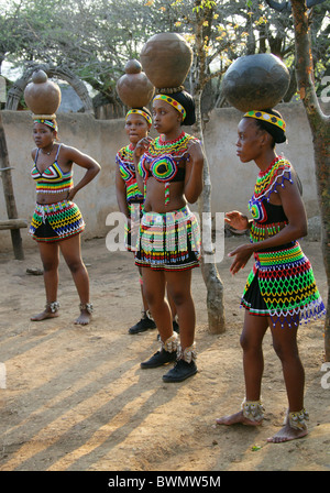 Zulu Girls Wearing Traditional Beaded Dress and Carrying Pots on their Heads, Shakaland Zulu Village, Kwazulu Natal, Africa Stock Photo