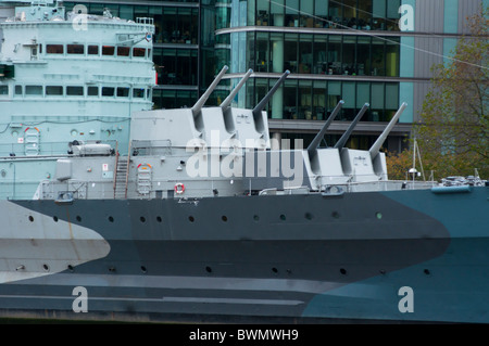 HMS Belfast Guns and offices behind, on river Thames in London England Stock Photo