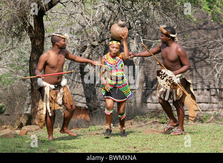 Young Zulu Warriors Flirting with a Zulu Maiden, Shakaland Zulu Village, Nkwalini Valley, Kwazulu Natal, South Africa. Stock Photo