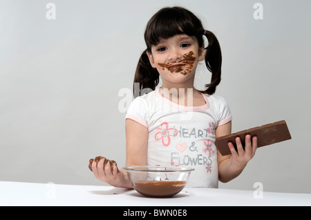 Girl with a pot full of melted chocolate and a chocolate bar Stock Photo