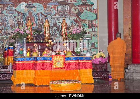 Buddhist monk standing beside an altar in Wenshu Temple, Chengdu, Sichuan Province, China Stock Photo