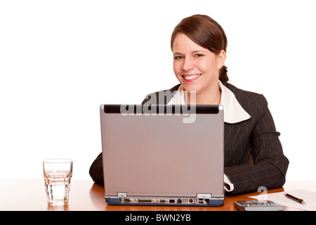 Young business woman sitting happy in office and works on computer. Isolated on white background. Stock Photo