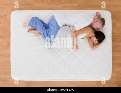 USA, Illinois, Metamora, Young couple sleeping on mattress Stock Photo