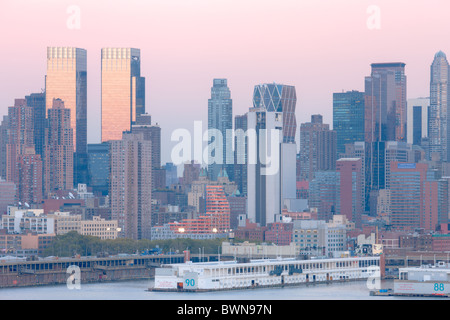 The Manhattan skyline at twilight behind the piers of the Manhattan Cruise Terminal on the Hudson River Stock Photo