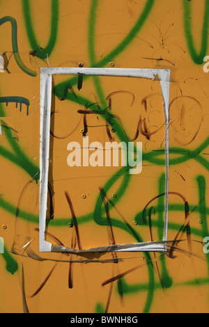 torn message on graffiti covered surface wall in city town Stock Photo