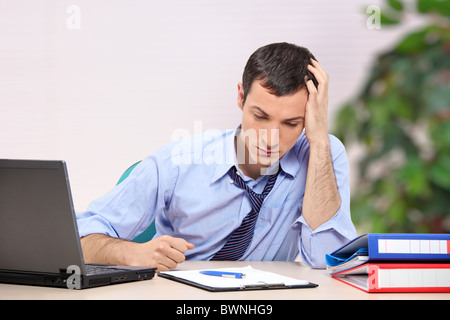 A desperate young businessman looking down Stock Photo