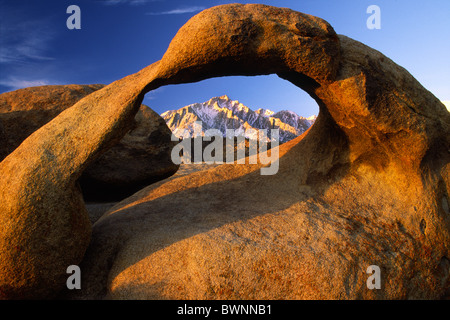 Granite arch in California's Alabama Hills with the Sierra Nevada range in the distance Stock Photo