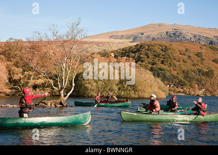 Llanberis, North Wales, UK. People playing ball games canoeing in Canadian canoes on Llyn Padarn Lake in Snowdonia National Park Stock Photo