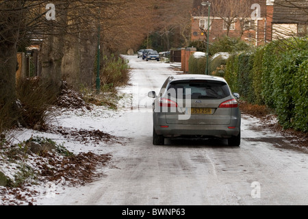 A car driving slowly along an ungritted country road in Nottingham England UK Stock Photo