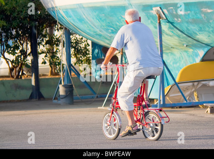 Elderly man riding a mini bicycle Stock Photo