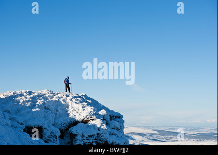 Female hiker stands on summit of Corn Du in winter, Brecon Beacons nationl park, Wales Stock Photo