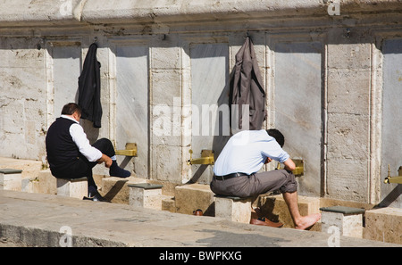 TURKEY Istanbul Sultanahmet The New Mosque or Yeni Camii Two men washing and making ablutions before prayer. Stock Photo