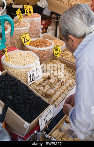 TURKEY Istanbul Sultanahmet The Spice Bazaar or Egyptian Bazaar Shopkeeper prepares display of dried fruit and nuts. Stock Photo