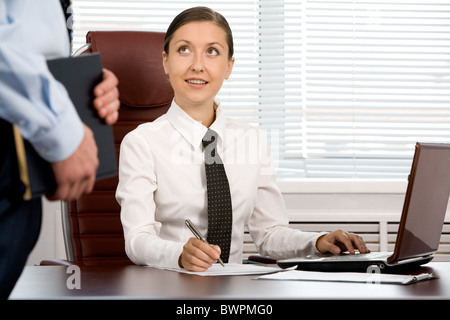 Portrait of happy receptionist looking at client with smile in office Stock Photo
