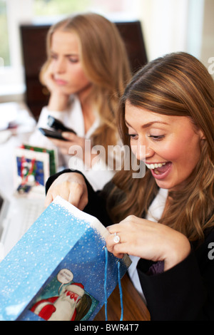Girls in office opening secret Santa presents Stock Photo