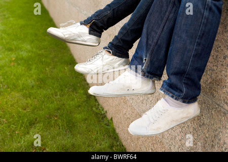Close-up of two pairs of feet wearing sportive shoes Stock Photo