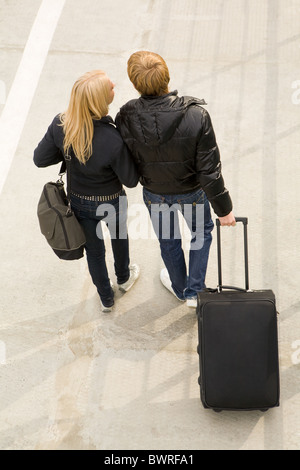 Above view of couple walking down trottoire with their baggage and chatting Stock Photo