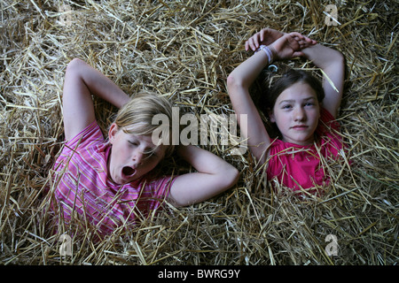 Switzerland Europe Indoor Inside Sleeping in the hay two girls persons kids children child sleeping sleep Stock Photo