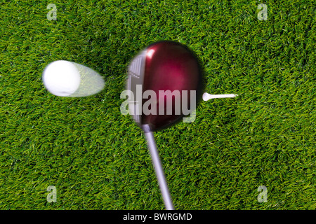 Photo of a driver hitting a golf ball off the tee with motion blur on the club and ball. Actual shot not photoshopped in. Stock Photo