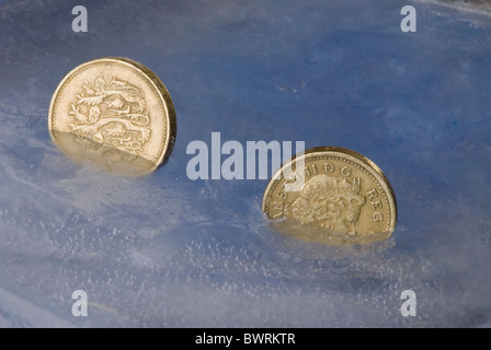 Frozen pound - coins suspended in ice economy Stock Photo