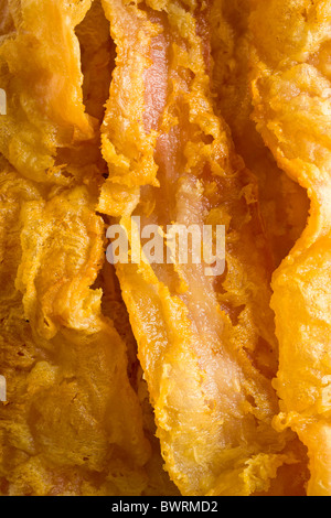 Chicken-Fried Bacon - Bacon slices dipped in a batter of whole dry milk and water, tossed in flour and deep fried. Stock Photo