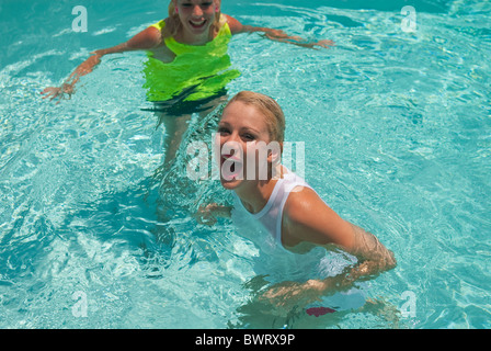 Two young women laughing in a swimming pool Stock Photo
