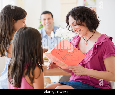 Daughters giving mother Mother's Day card Stock Photo