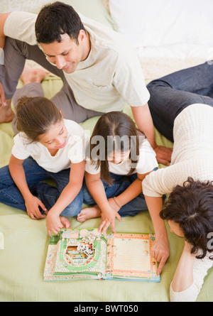 Parents reading storybook to daughters Stock Photo