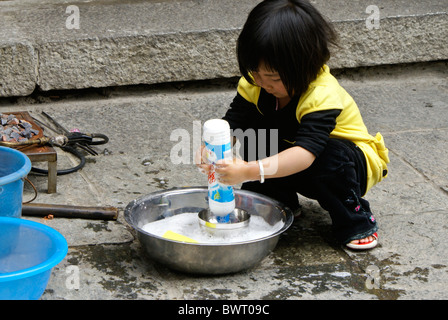 Little girl playing in water, Dali, Yunnan, China Stock Photo