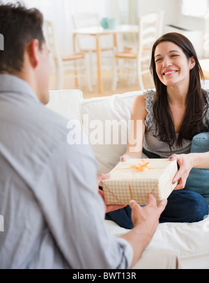Husband giving gift to happy wife Stock Photo
