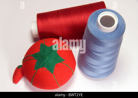 Pin cushion and thread on a white background. Stock Photo