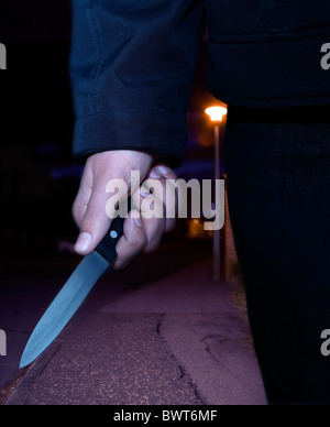Close up of a male hand carrying a knife at night Stock Photo