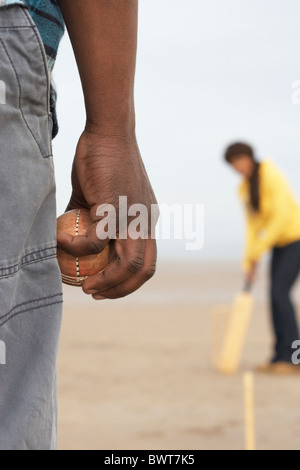 Young Couple Playing Cricket On Autumn Beach Holiday Stock Photo