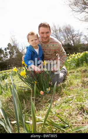 Father And Son On Easter Egg Hunt In Daffodil Field Stock Photo